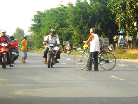 Đẩy xe đạp ngang qua đường như thế này là hết sức nguy hiểm, rất dễ xảy ra tai nạn.