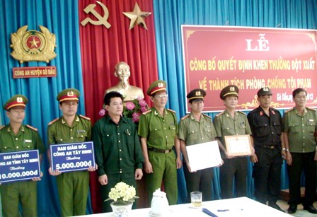 Đại tá Lý Hồng Sinh- Phó Giám đốc Công an tỉnh Tây Ninh, ông Võ Văn Dũng- Chủ tịch UBND huyện Gò Dầu trao thưởng